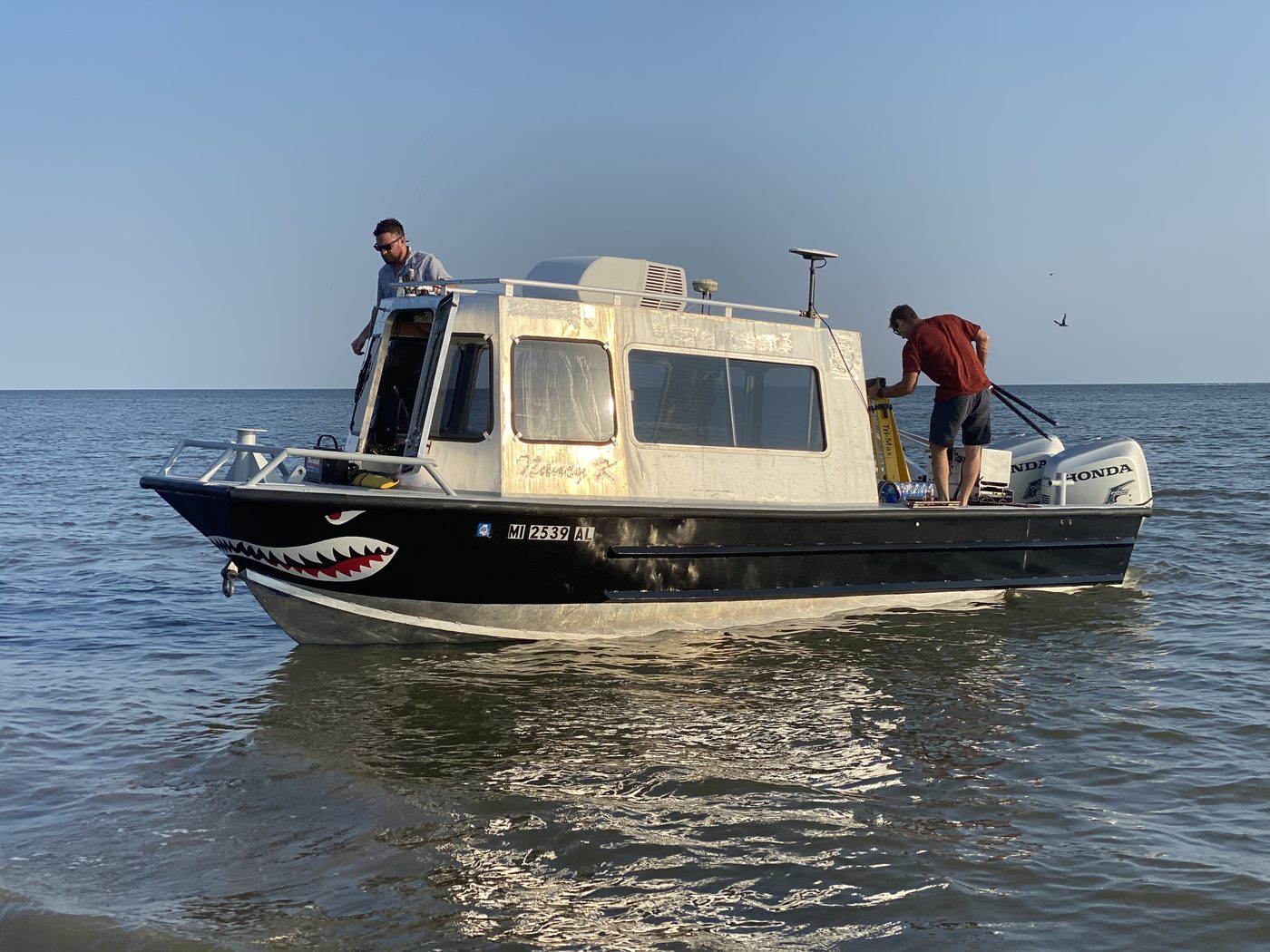 DIMCO survey crew aboard the Nancy K hydrographic survey boat with GNSS antenna