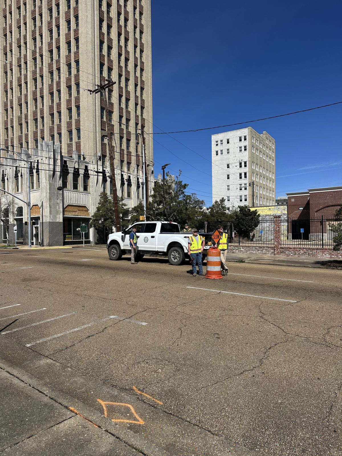 DIMCO crew surveying a downtown street with survey truck and traffic cones