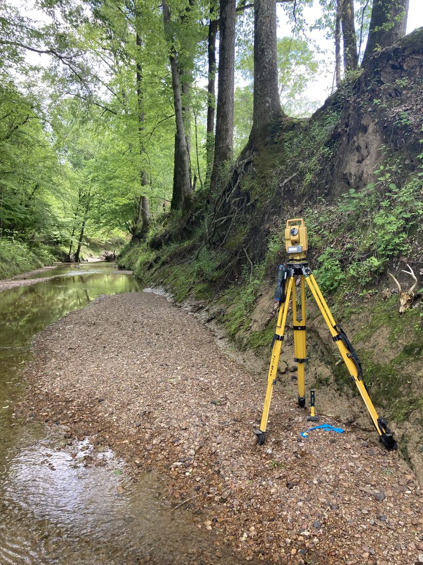Total station set up along a creek bottom for a boundary survey